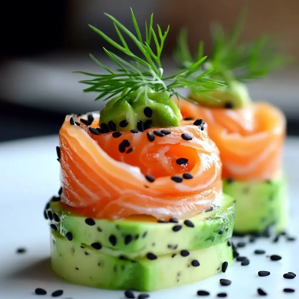 A gourmet dish featuring salmon rose garnished with a slice of green pepper and fresh dill, resting on layers of cucumber, sprinkled with black sesame seeds.