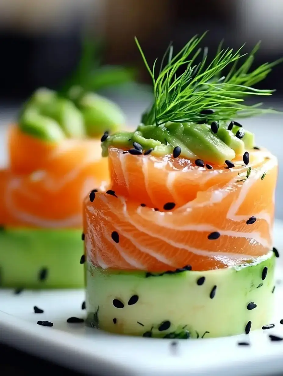 A close-up of sushi featuring layered slices of salmon and avocado, topped with black sesame seeds and garnished with fresh dill.